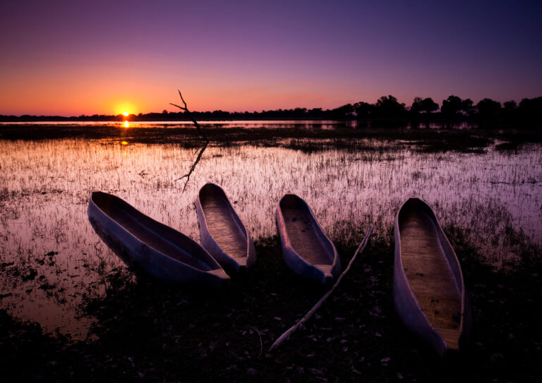 Mokoro canoe safari at sunset on the Okavango Delta near Kwara Camp.