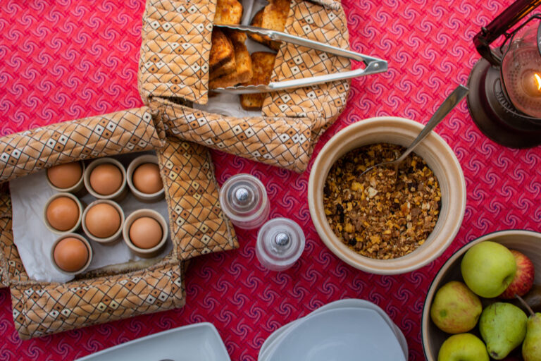 Bush breakfast spread with eggs, fruit, and pastries at Kwara Camp.