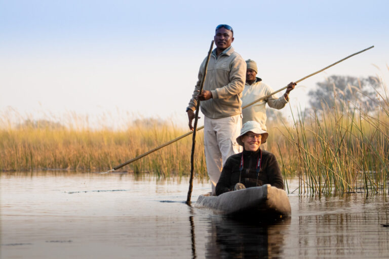 Guest enjoying a mokoro canoe ride guided by local polers in the Okavango Delta.