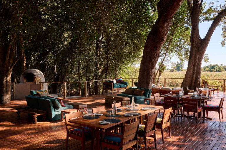 The dining area at Nxamaseri Island Lodge under the canopy of shade overlooks the Okavango waters