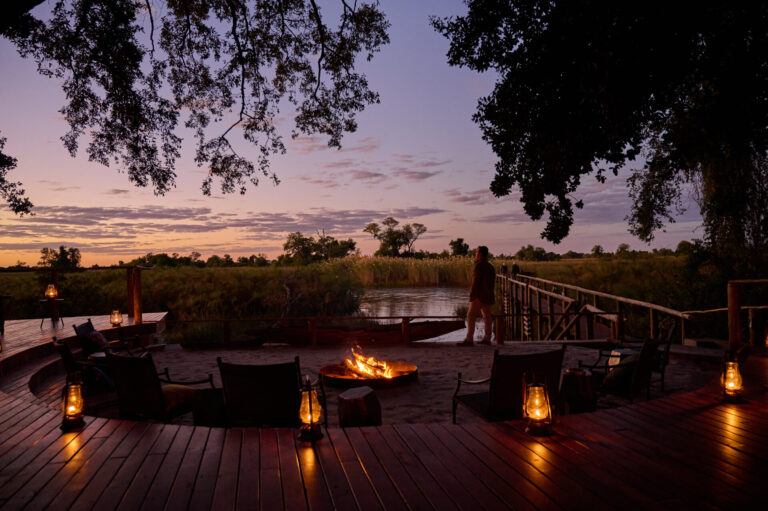 The firepit area lit at dusk just below the main area of Nxamaseri Island Lodge