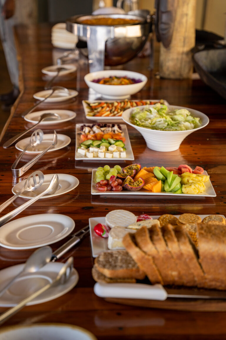 Breakfast buffet with bread, fruit, and cold dishes at Pom Pom Camp.