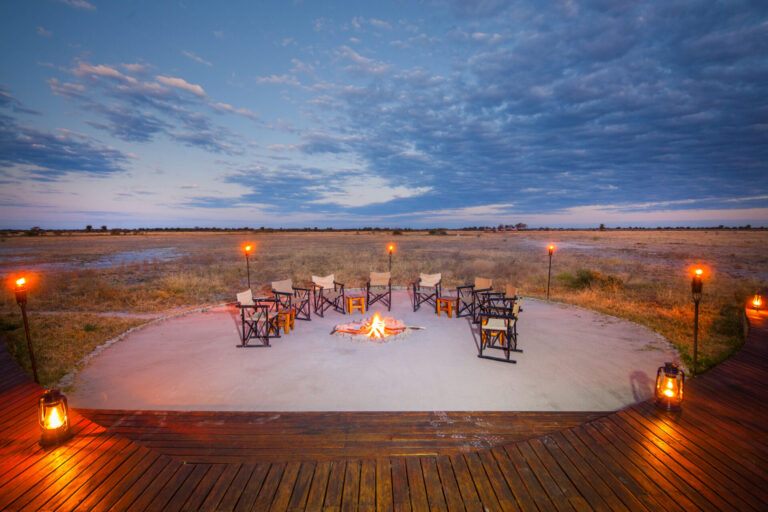 Campfire and chairs arranged in a circle overlooking the plains at Nxai Pan Camp.
