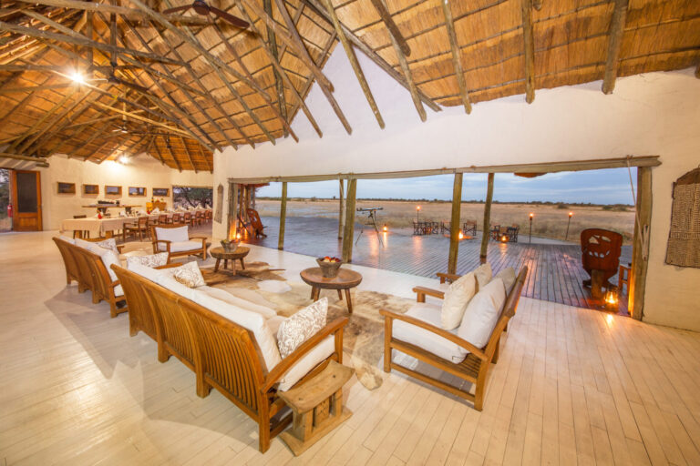 Open thatched lounge overlooking the pool and plains at Nxai Pan Camp.