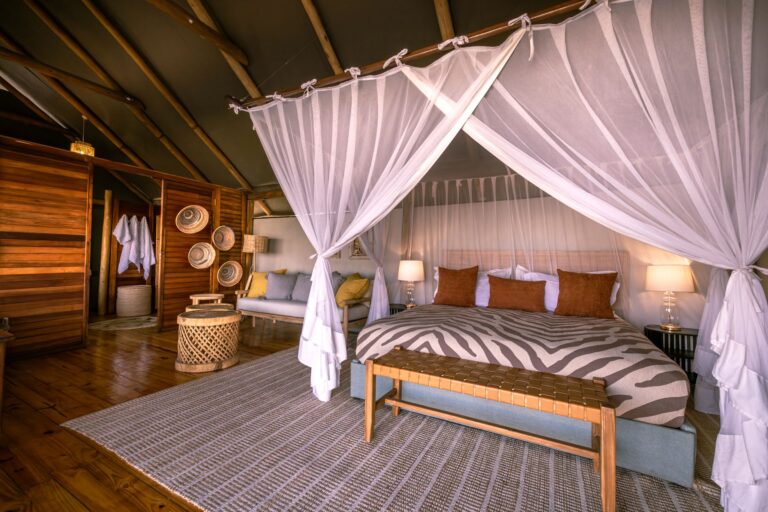 Spacious suite tent with double four poster bed, mosquito net, lounge area and ensuite bathroom.