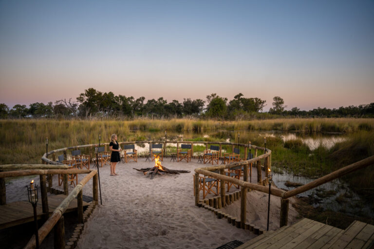 Circular firepit area with chairs overlooking floodplains at Four Rivers Camp.