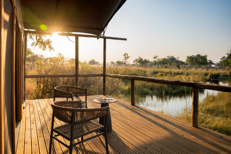 Wooden deck with chairs overlooking a water channel at Four Rivers Camp.