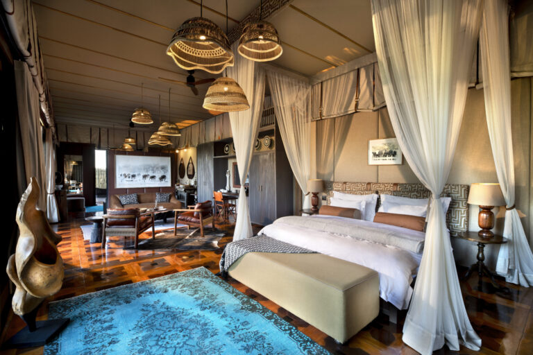Atzaró Okavango Camp luxury bedroom suite with four-poster bed and refined decor in Botswana.
