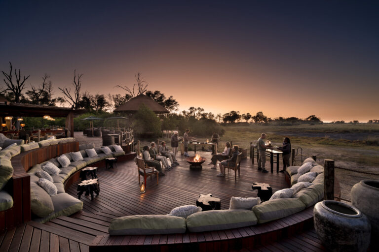 Fire pit and lounge deck at Atzaró Okavango Camp at sunset in Botswana.