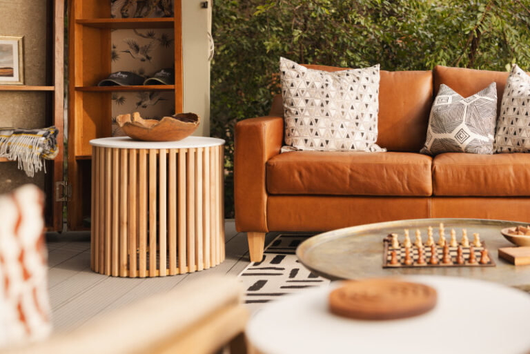 Stylish main area at King Lewanika Lodge featuring a leather sofa, rustic coffee table, and elegant decor